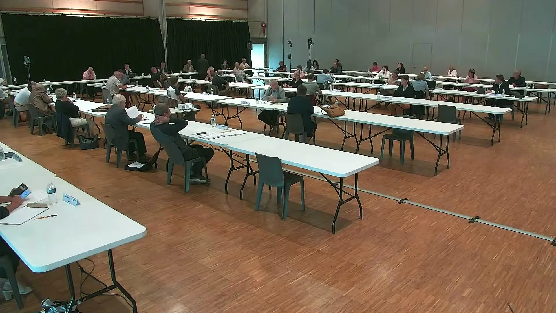 Plan large d'un conseil communautaire de Châteaubriant-Derval : les élus installés à des tables espacées dans une grande salle