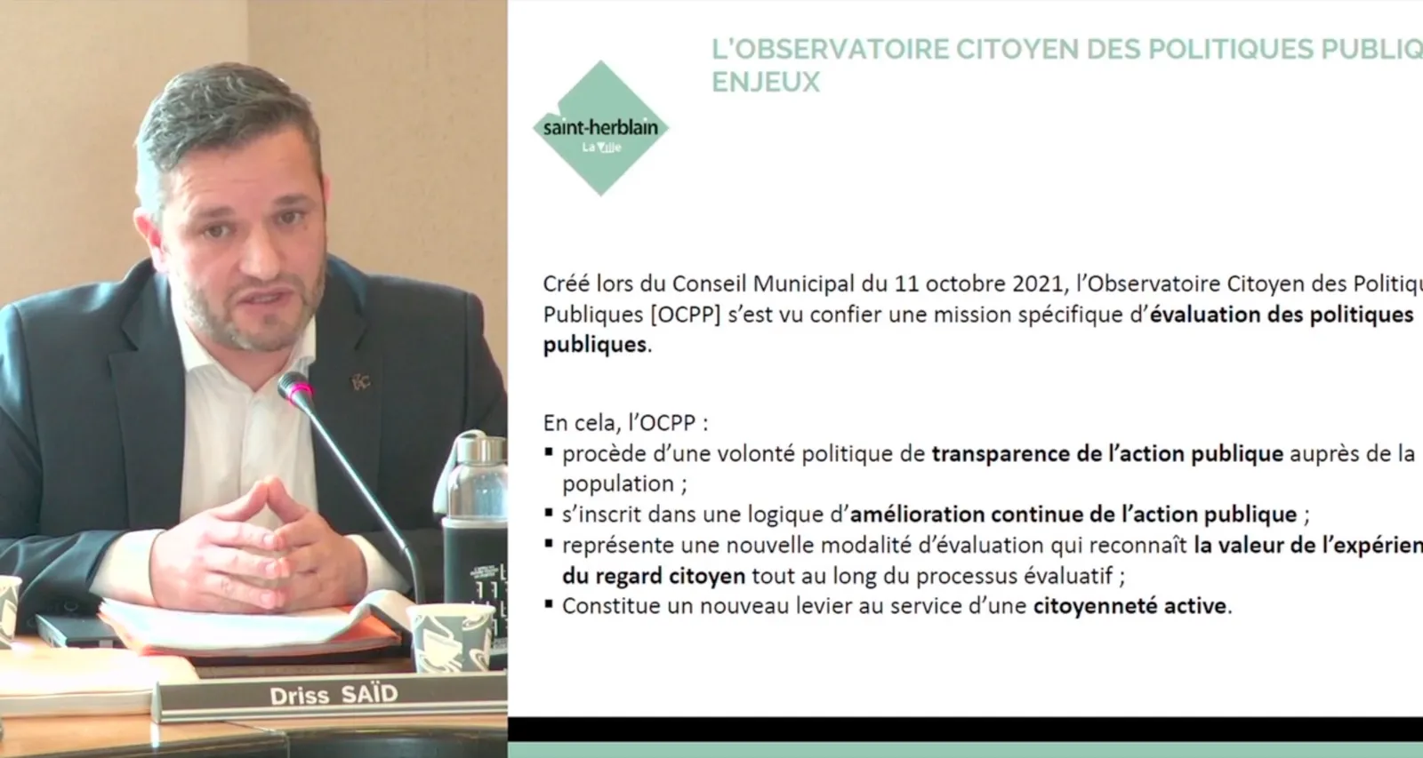 Un intervenant au micro, son nom à l'écran, avec le document projeté affiché à côté de lui